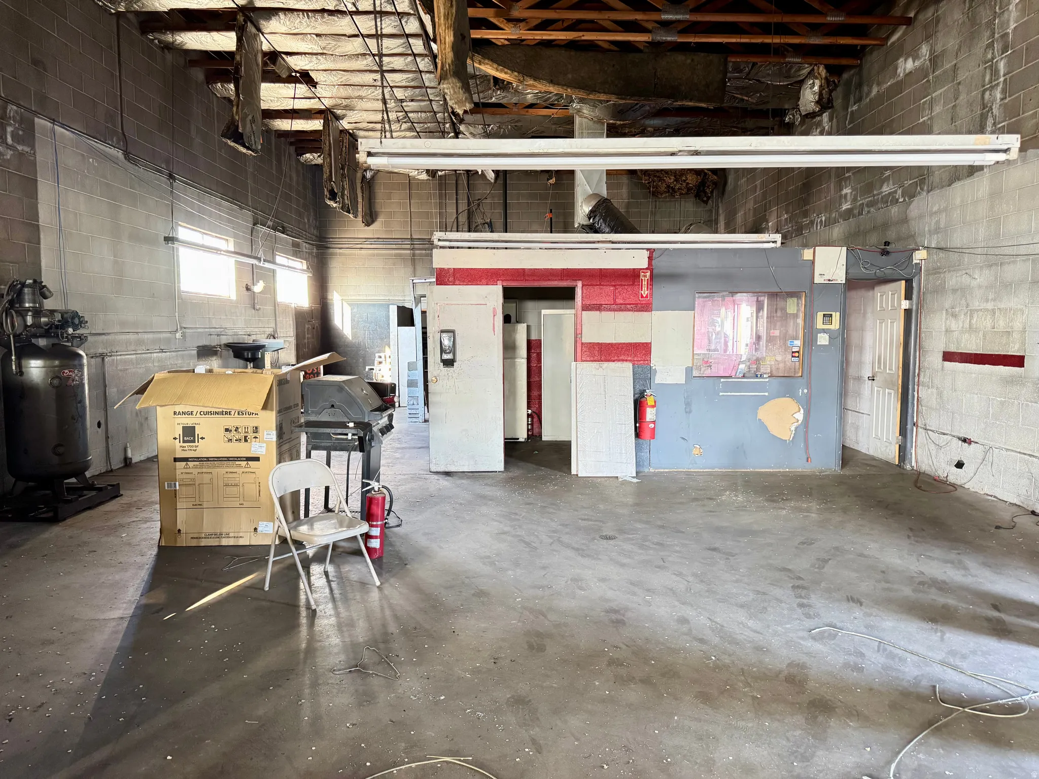 Spacious interior featuring concrete block walls, a concrete floor, and exposed ceiling joists