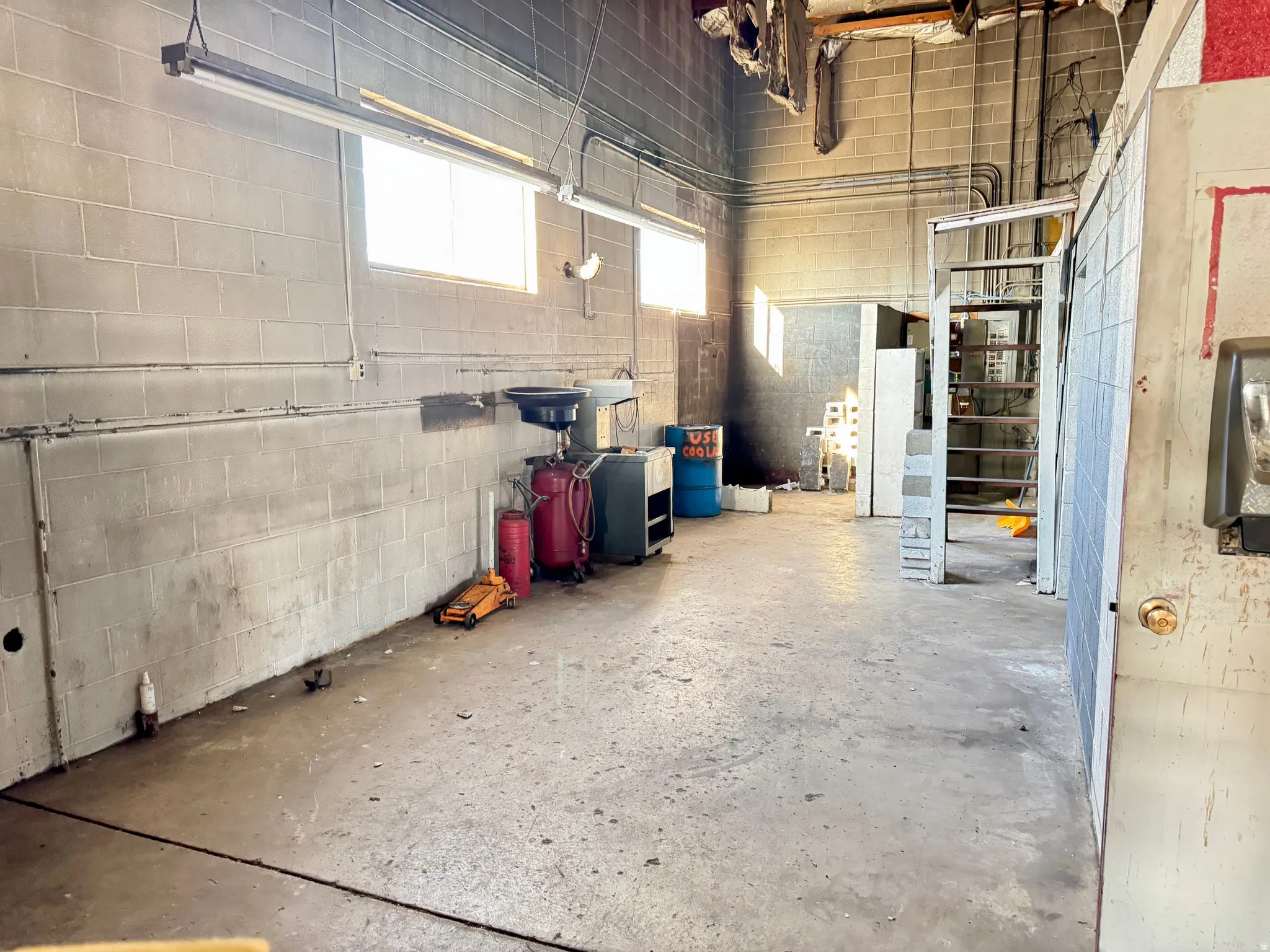 Spacious open-concept commercial interior featuring concrete block walls and a concrete floor