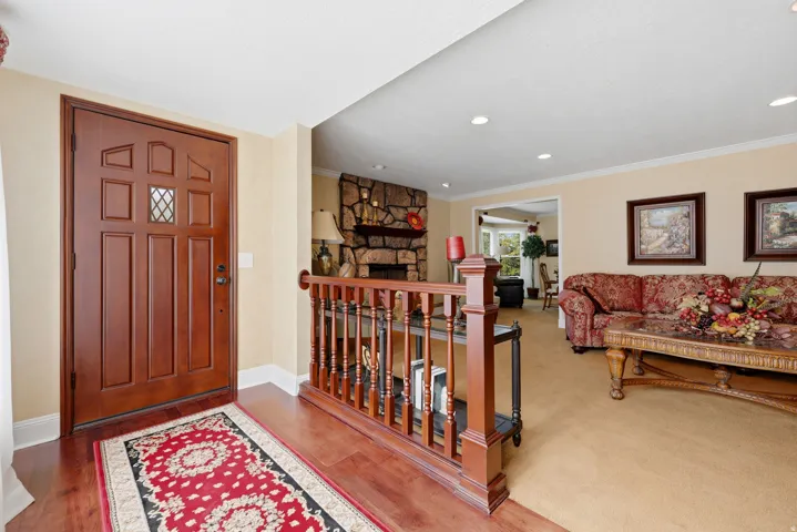 Wood-finish flooring welcomes at the entry, featuring a paneled front door with diamond-pane glass detail