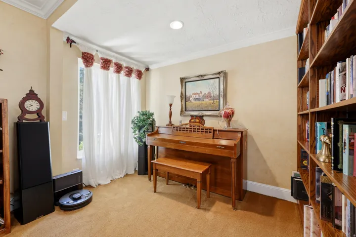 Room featuring extensive wood-finish built-in shelving, crown molding, and recessed lighting