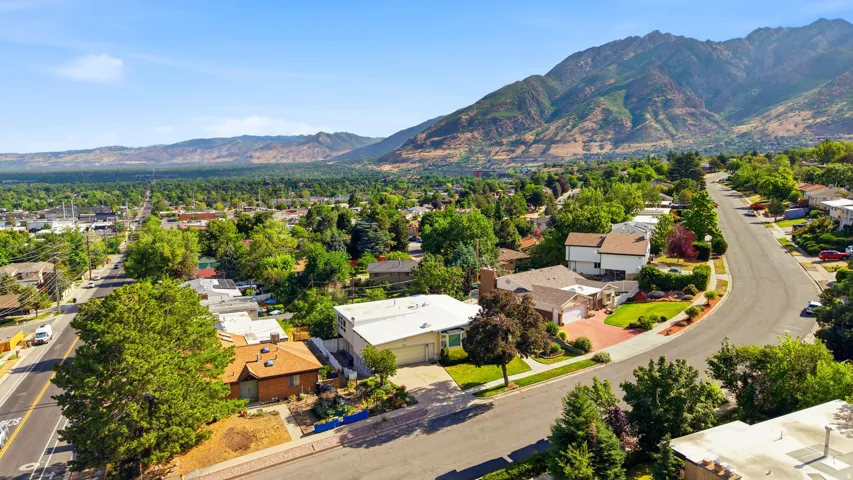 Expansive mountain range backdrop framing a residential neighborhood with mature trees and paved streets