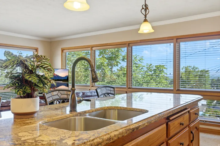 Kitchen island featuring a dual basin stainless steel sink with a high-arch bronze faucet