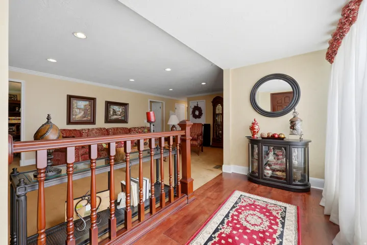 Rich wood-finish flooring complements the detailed wood banister