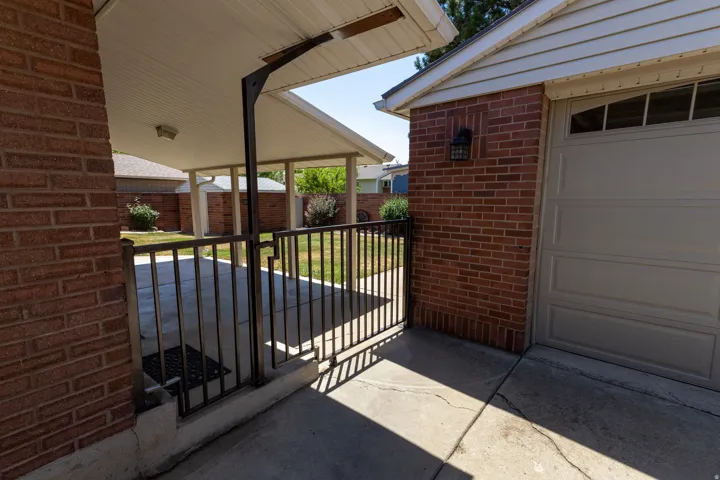 Brick exterior with an attached garage and covered carport