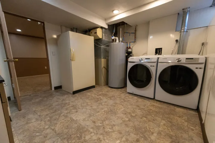 Utility area featuring patterned tile flooring and recessed lighting