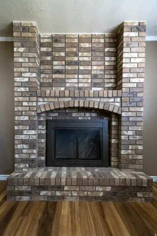 Two-tone brick fireplace with an arched firebox opening and a raised hearth