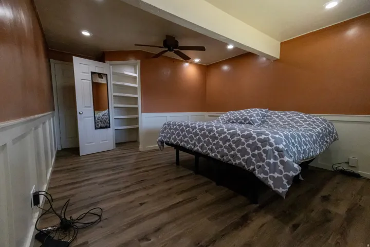 Spacious room featuring wood-finish flooring, recessed lighting, and a ceiling fan