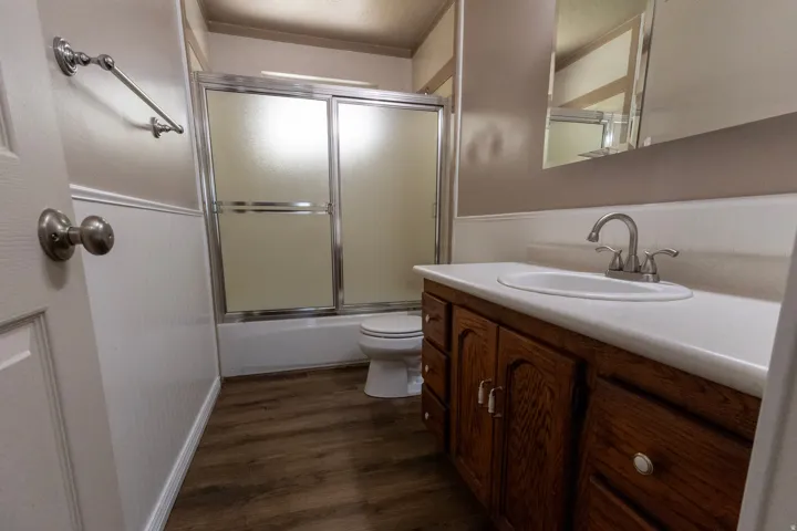 Bathroom featuring a wood-finish vanity with an integrated sink and brushed nickel fixtures