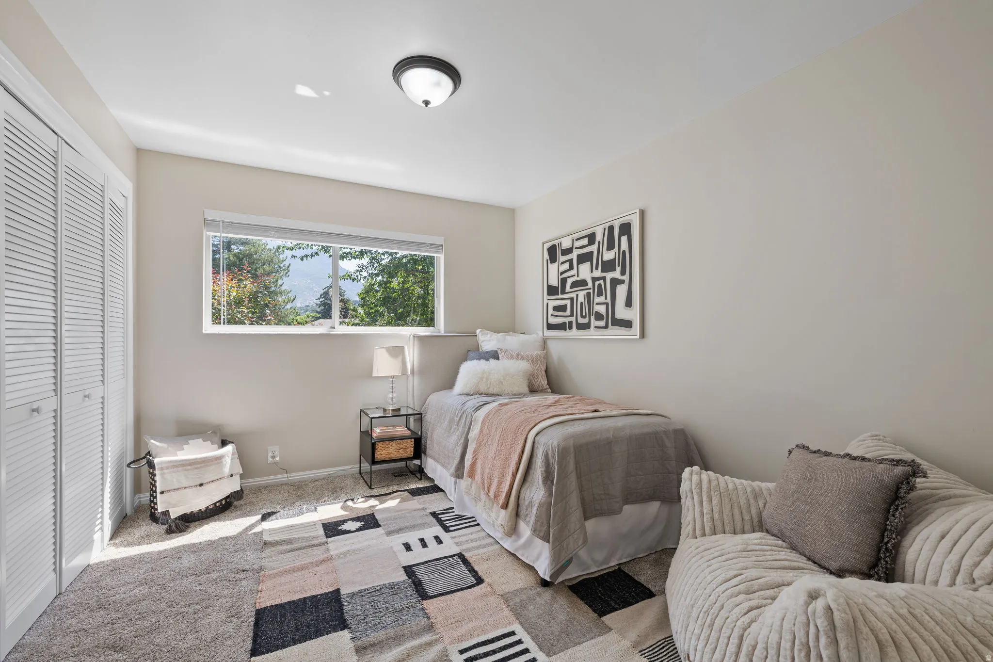 Bedroom featuring a window with exterior views, carpeted flooring, and a flush-mount ceiling light