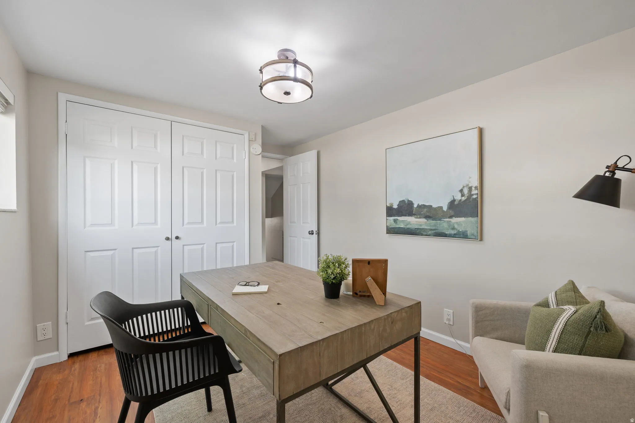 Neutral wall tones, wood-finish flooring, and a contemporary ceiling light fixture