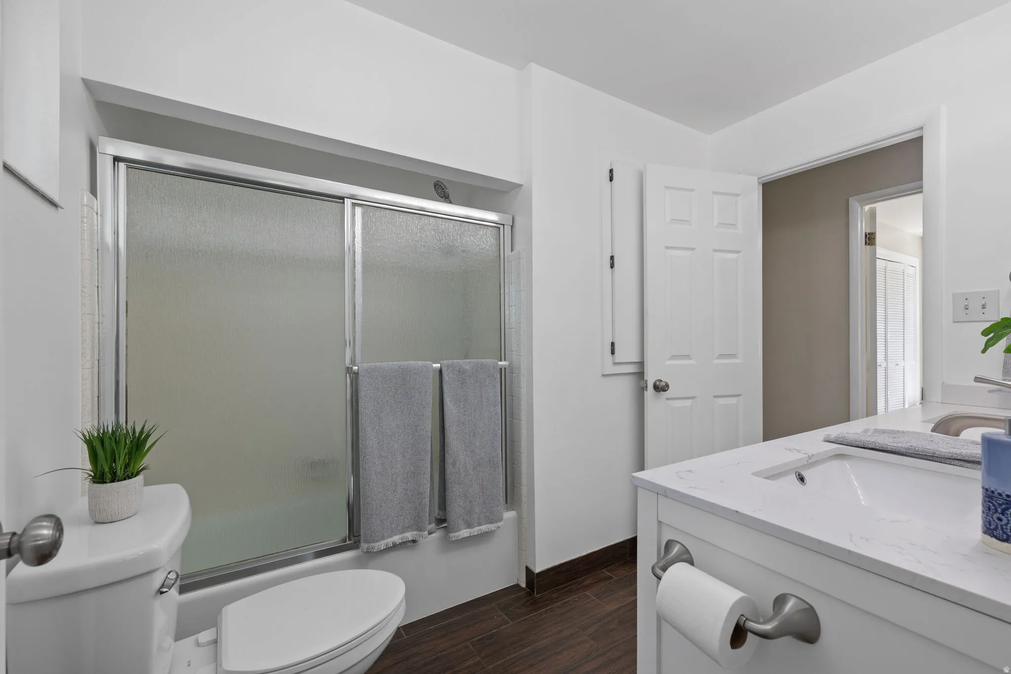Bathroom featuring a white vanity with an integrated sink, silver-toned faucet, and a quartz-finish countertop