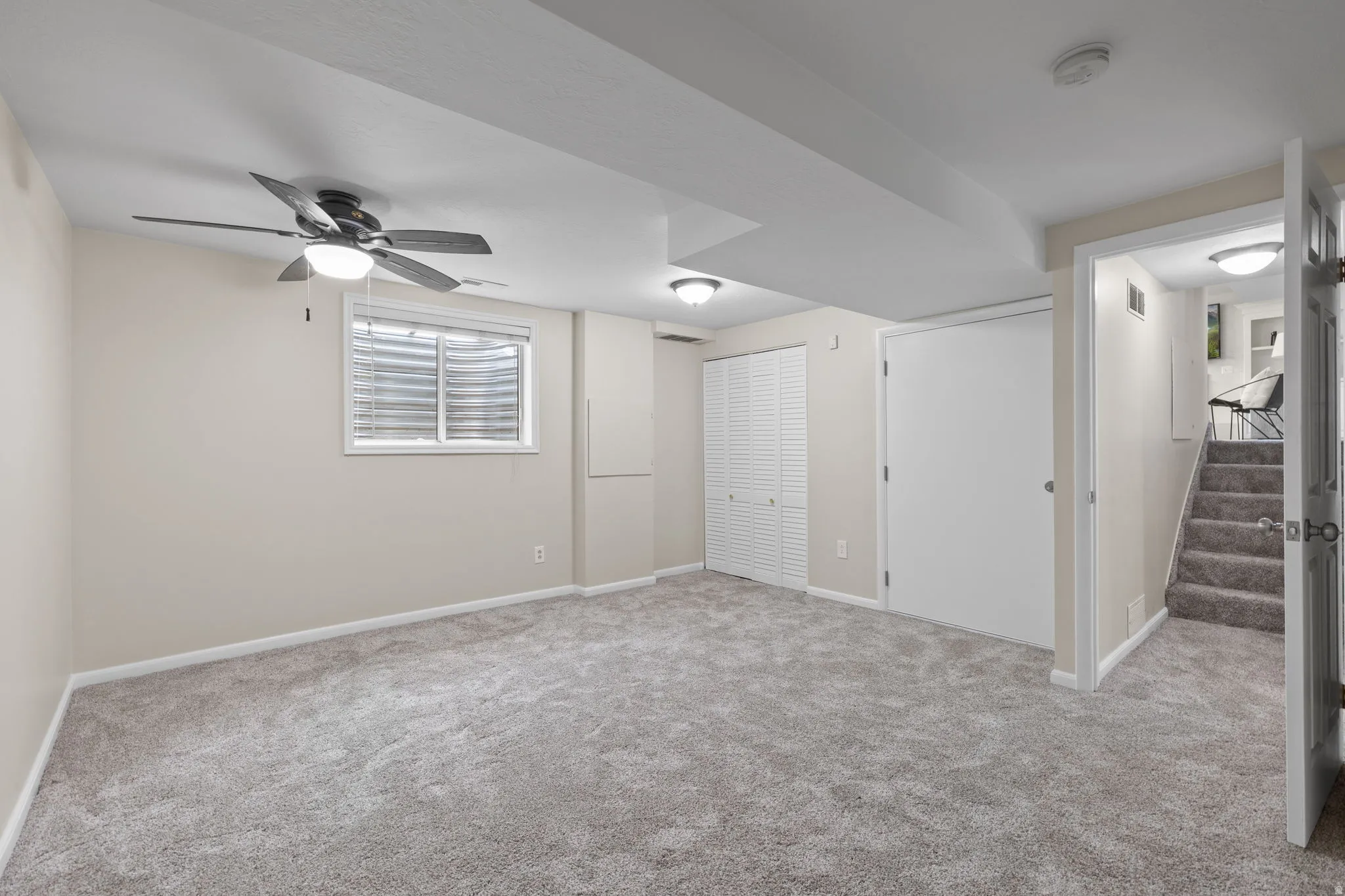 Spacious room featuring neutral carpet, a ceiling fan with integrated lighting, recessed lighting, and a window with blinds.