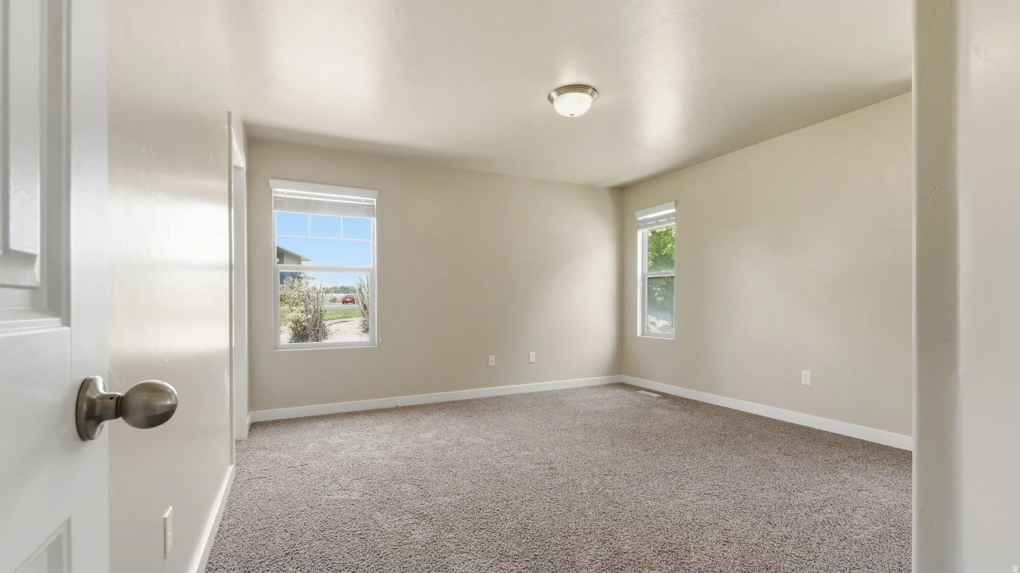 Spacious room featuring neutral carpeting and light-toned walls