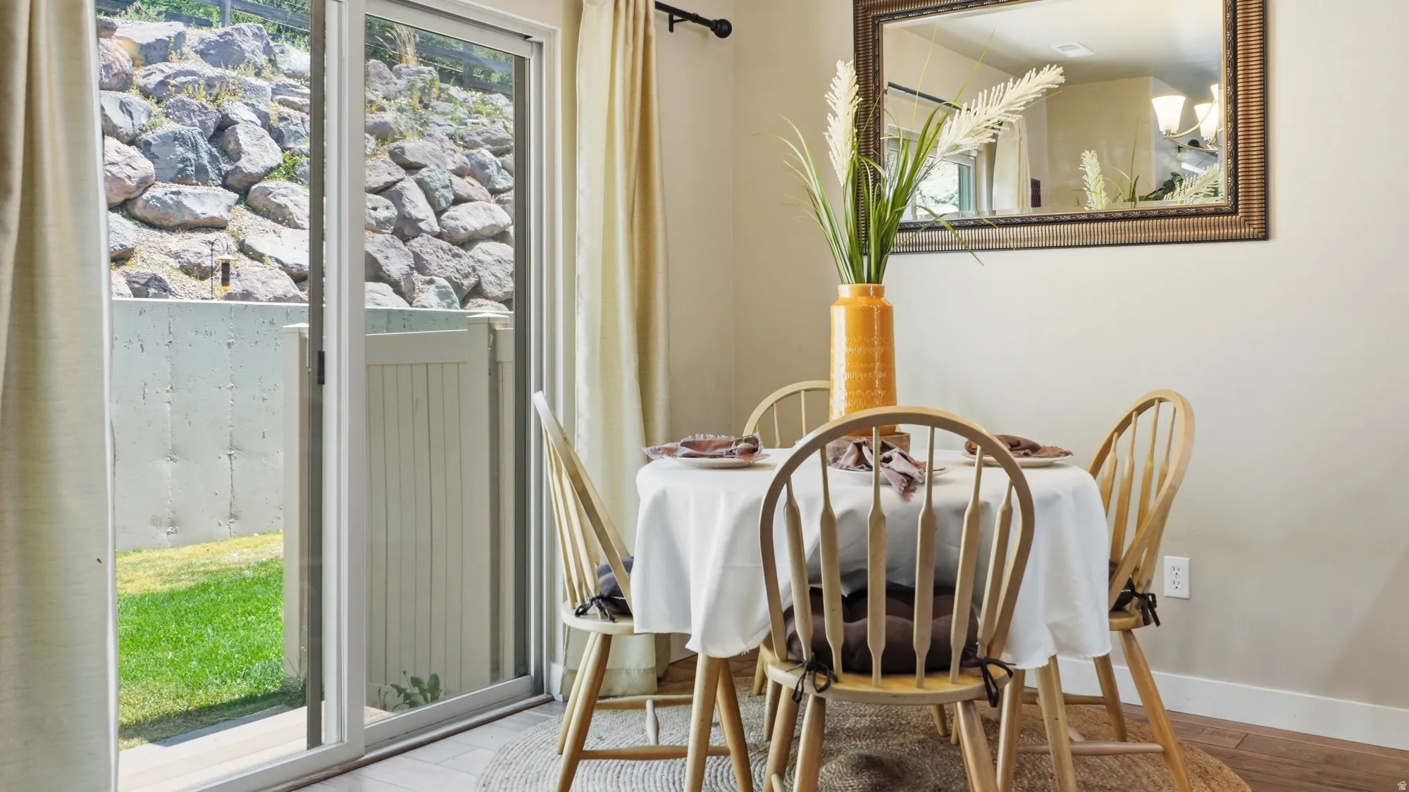 Dining area featuring wood-finish flooring and a contemporary mirror