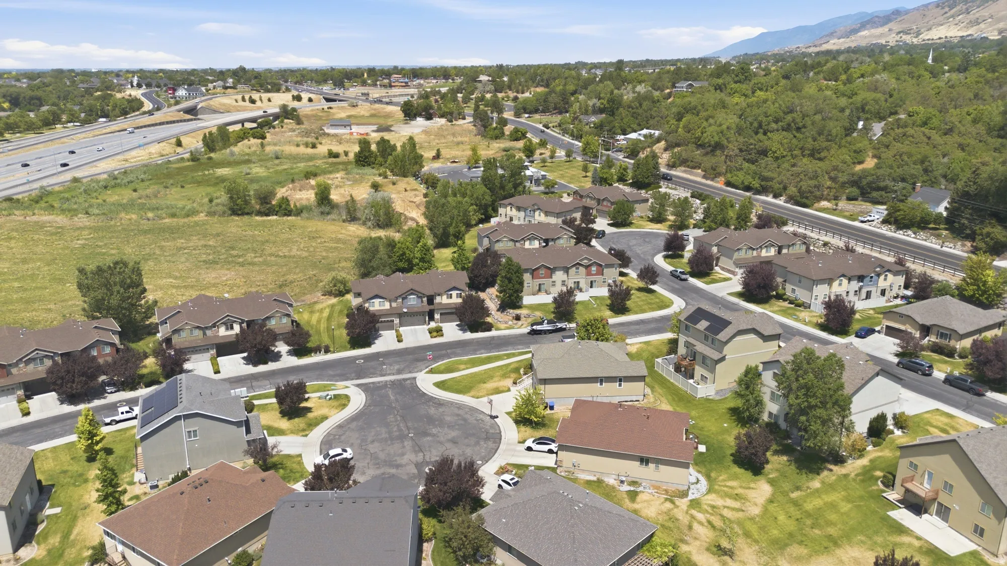 Residential community featuring multiple two-story homes and townhouses arranged along paved streets