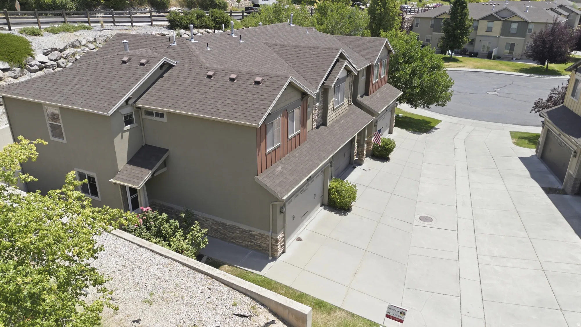 Multi-level residential structure featuring a shingled roof and a combination of stucco and wood-finish siding