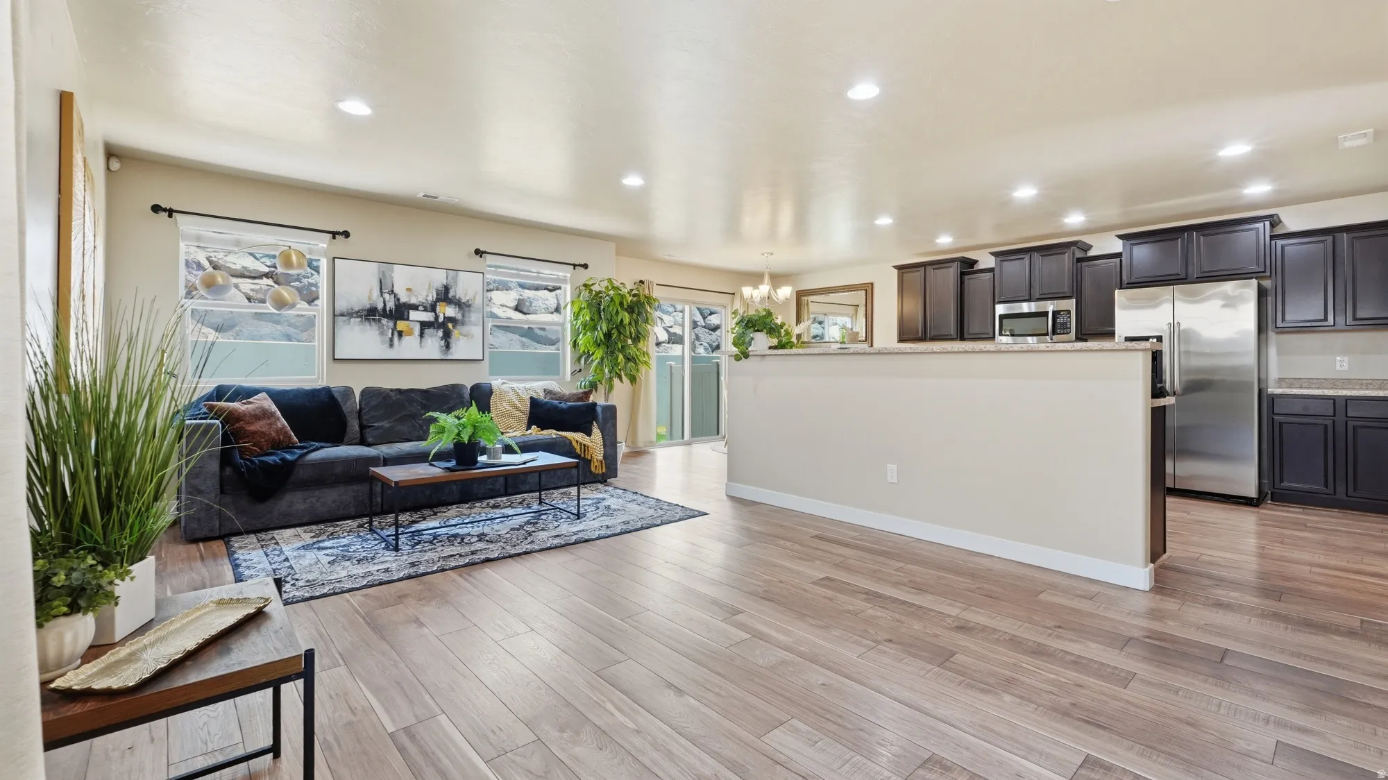 Open-concept living space featuring wood-finish flooring, recessed lighting, and a neutral color palette