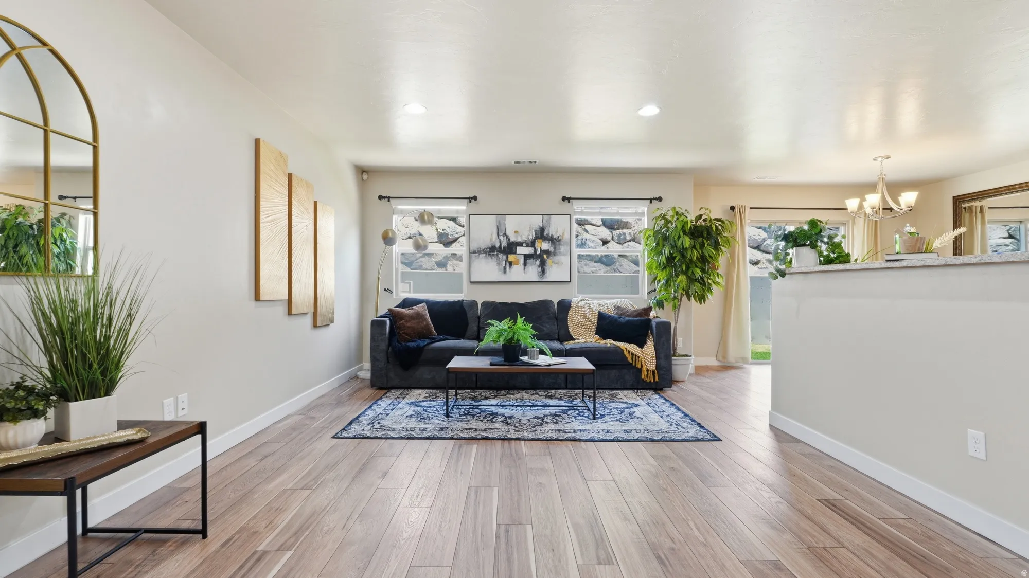 Open concept living area featuring wood-finish flooring, light-toned walls, and recessed lighting