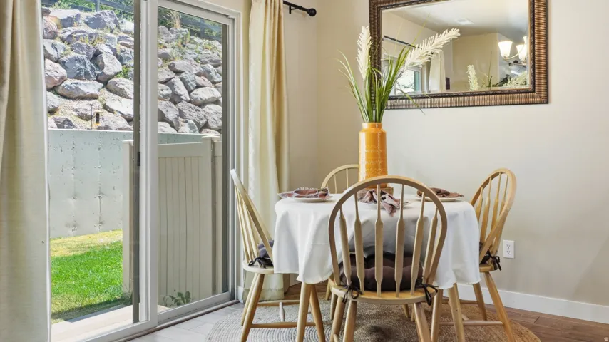 Dining area featuring wood-finish flooring and a contemporary mirror