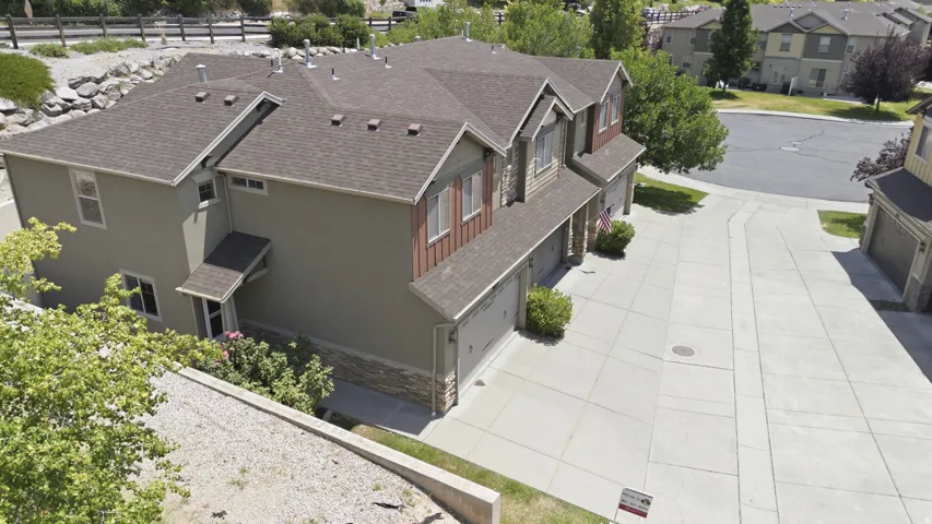 Multi-level residential structure featuring a shingled roof and a combination of stucco and wood-finish siding