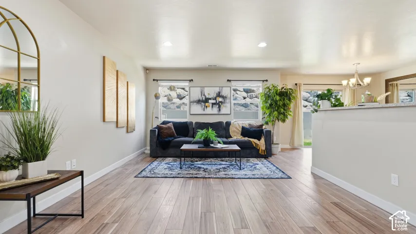 Open concept living area featuring wood-finish flooring, light-toned walls, and recessed lighting