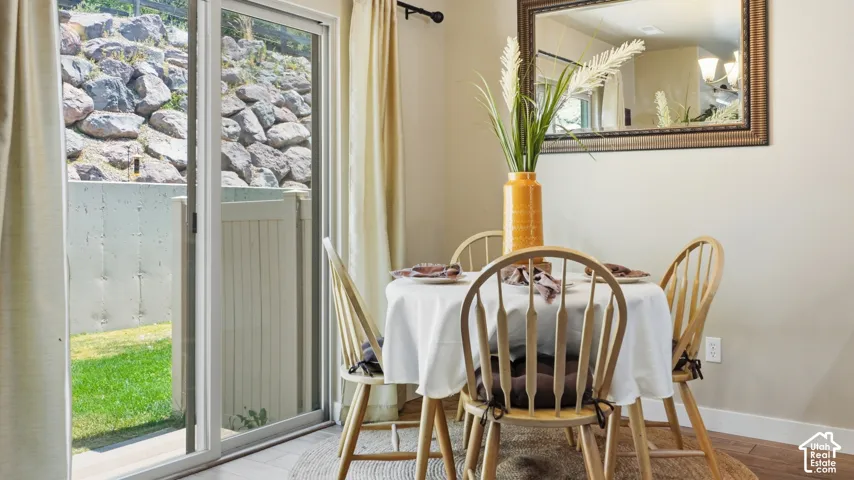 Dining area featuring wood-finish flooring and a contemporary mirror