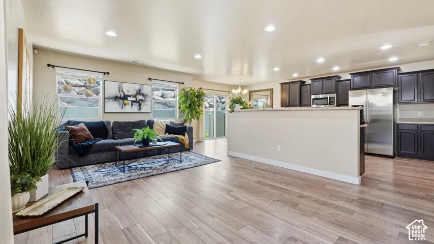 Open-concept living space featuring wood-finish flooring, recessed lighting, and a neutral color palette