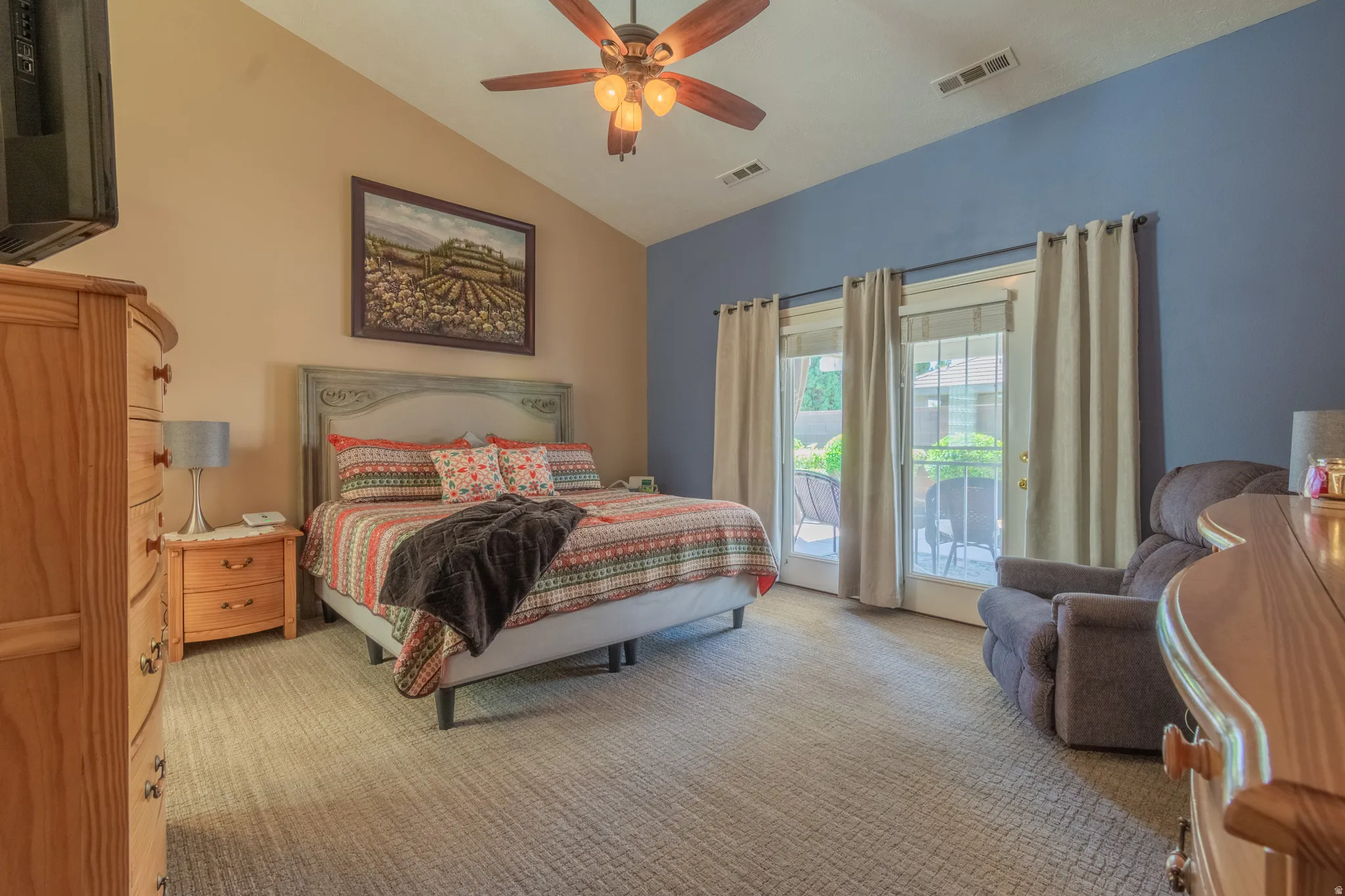 Vaulted bedroom with dual French doors offering direct outdoor access