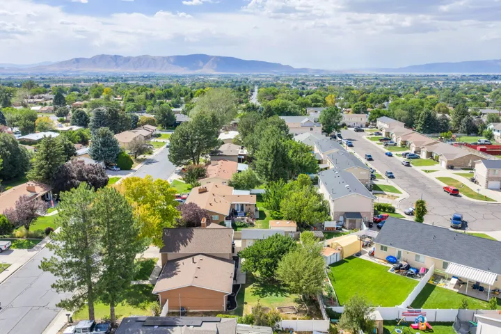 Residential neighborhood featuring a grid-style layout, mature trees, and mountainous terrain in the distance