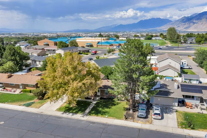 Aerial perspective showcasing residential properties, mature trees, and distant mountains