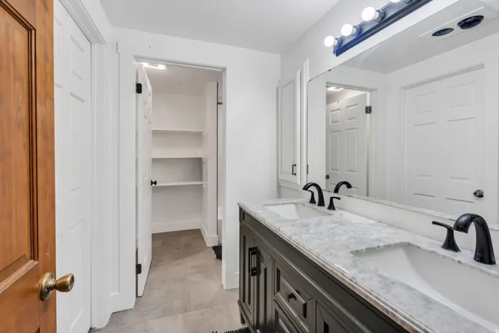 Dual vanity with stone countertop, undermount sinks, and matte black fixtures