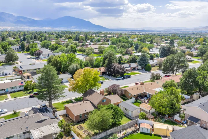 Mature trees throughout the neighborhood, residential streets, and mountain backdrop