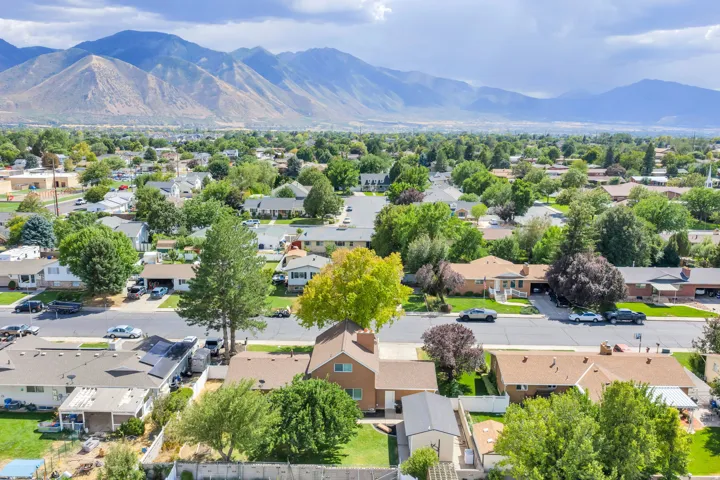 Expansive mountain backdrop with a neighborhood featuring mature trees and established residential properties