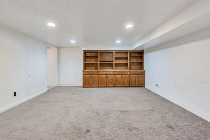 Recessed lighting illuminating a spacious room with light gray carpeting