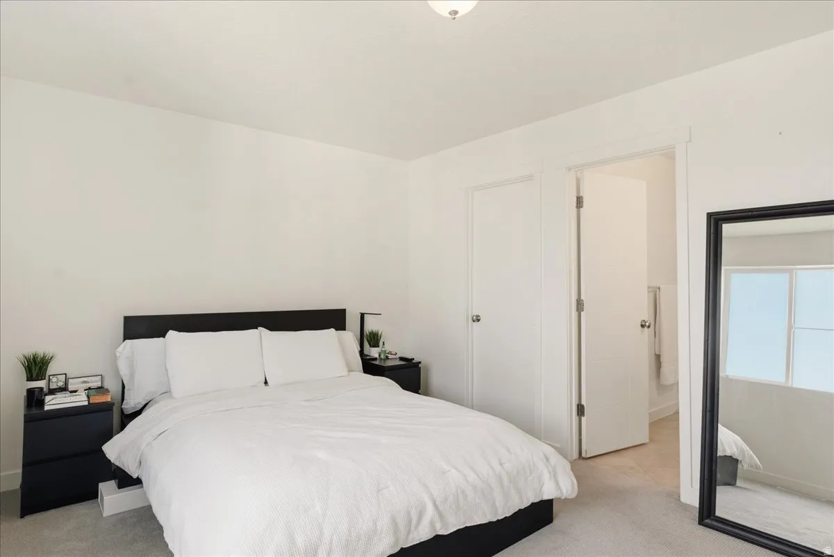 Carpeted bedroom featuring white walls and trim, a flush-mount ceiling light, and two white interior doors