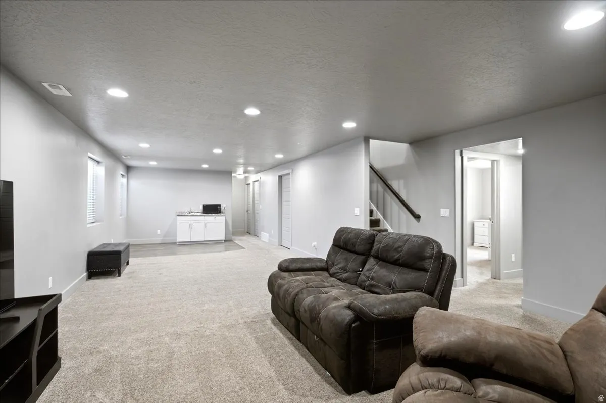 Expansive lower-level space featuring recessed lighting, light-toned carpeting, and neutral wall finishes
