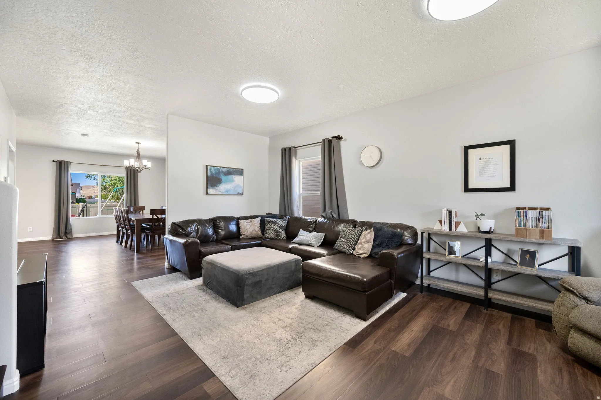 Spacious living area featuring wood-finish flooring, light gray walls, and recessed lighting