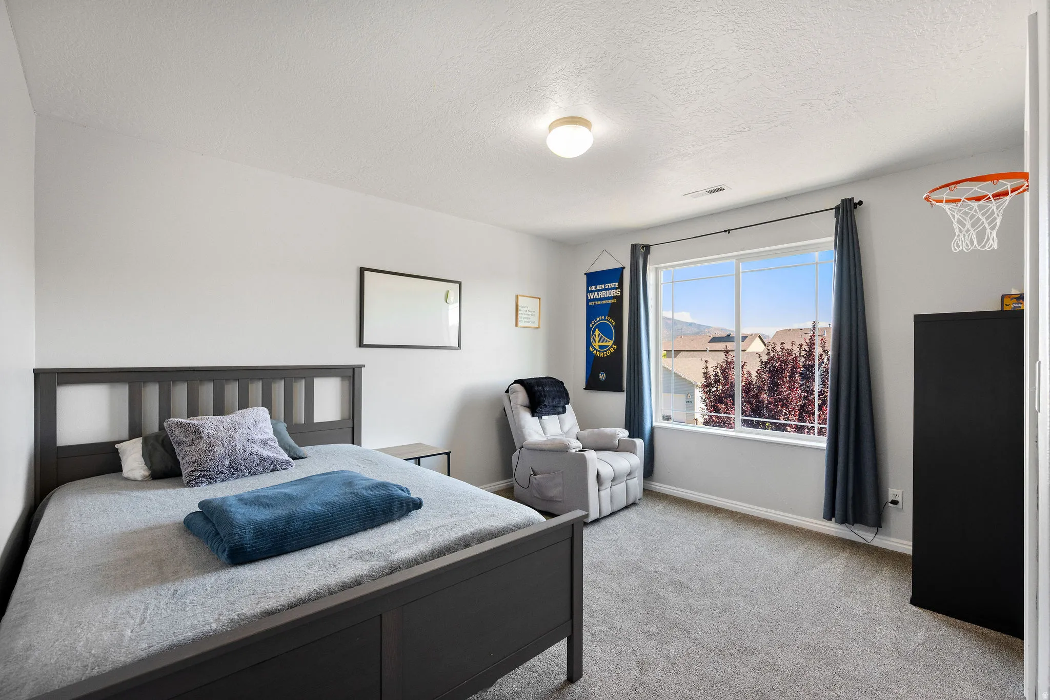 Spacious room featuring neutral paint, gray carpeting, a large window, and a flush mount ceiling light