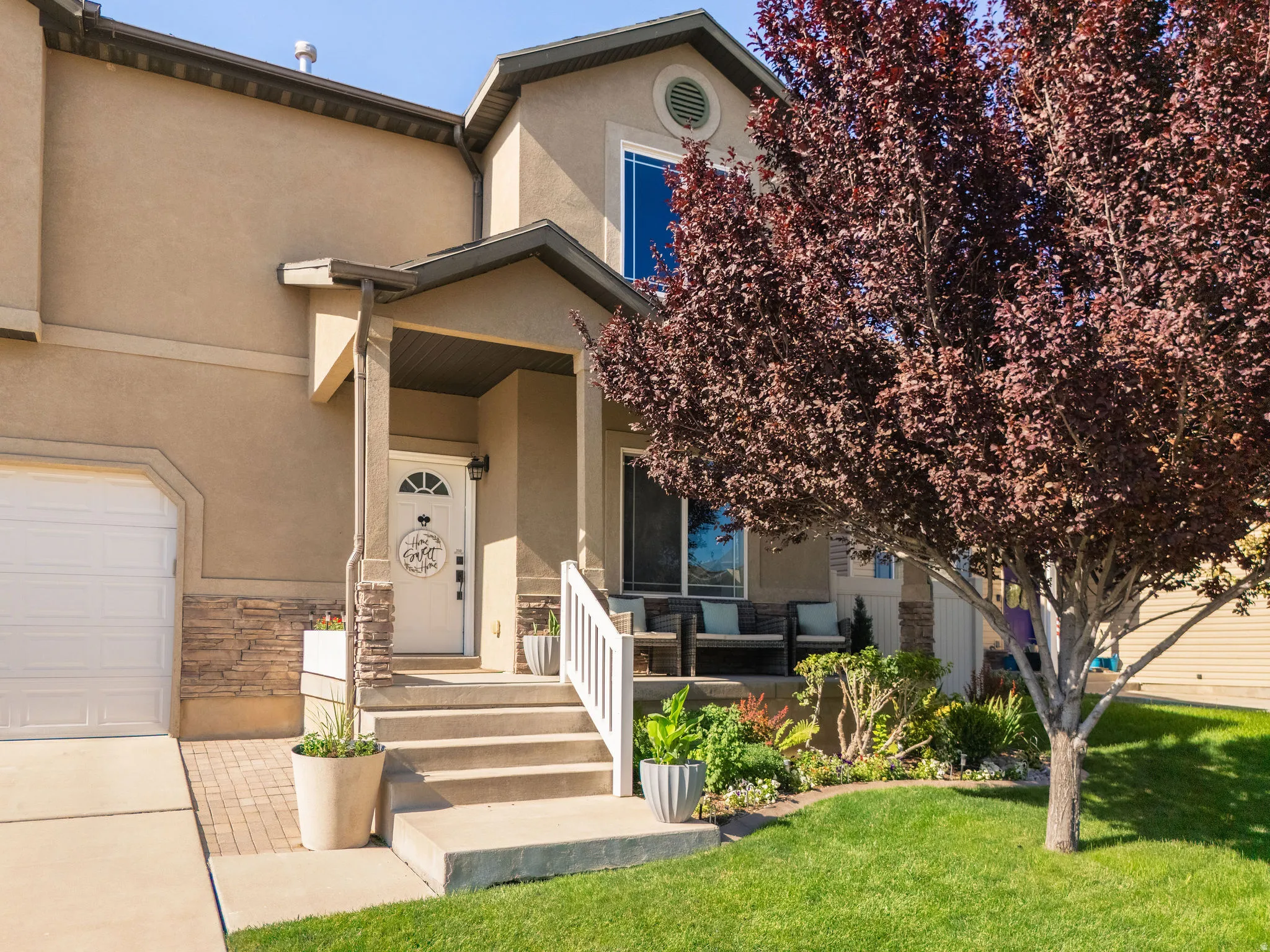Stucco exterior featuring stacked stone accents