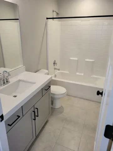 Bathroom featuring a white bathtub and shower combination with a black shower curtain rod