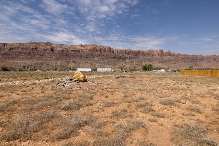 Expansive land parcel with natural terrain and distant red rock formations