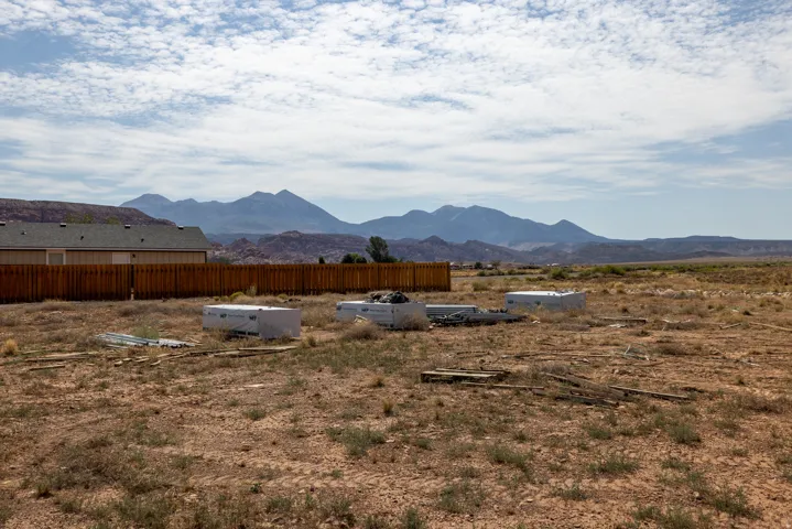 Expansive desert landscape featuring distant mountains under a cloudy sky
