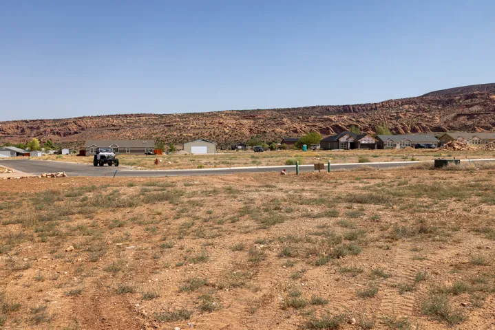 Expansive desert lot featuring a clear, level building area and visible utilities