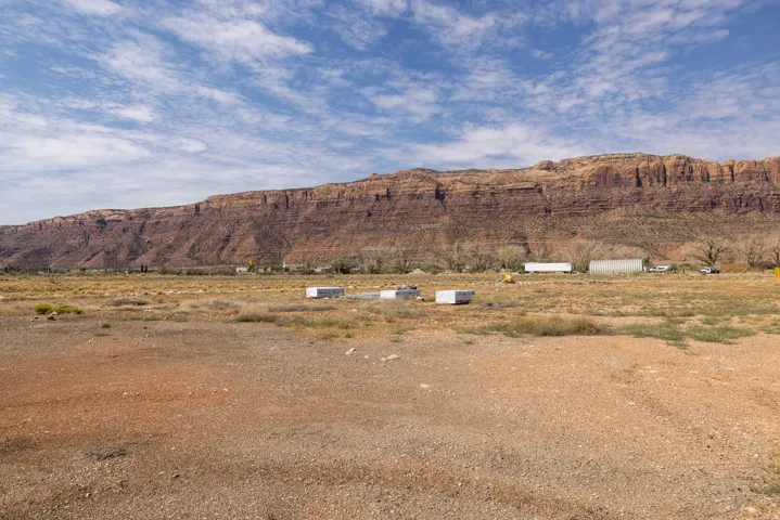 Expansive open terrain featuring a prominent rock formation backdrop