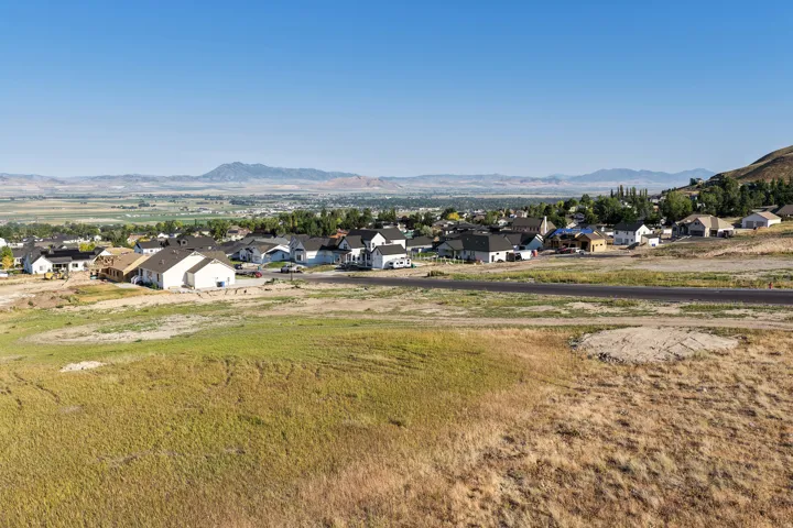 Expansive landscape featuring distant mountains and a developing residential area with new construction