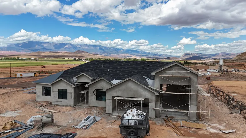 New construction residence featuring a dark shingle roof and a stucco exterior