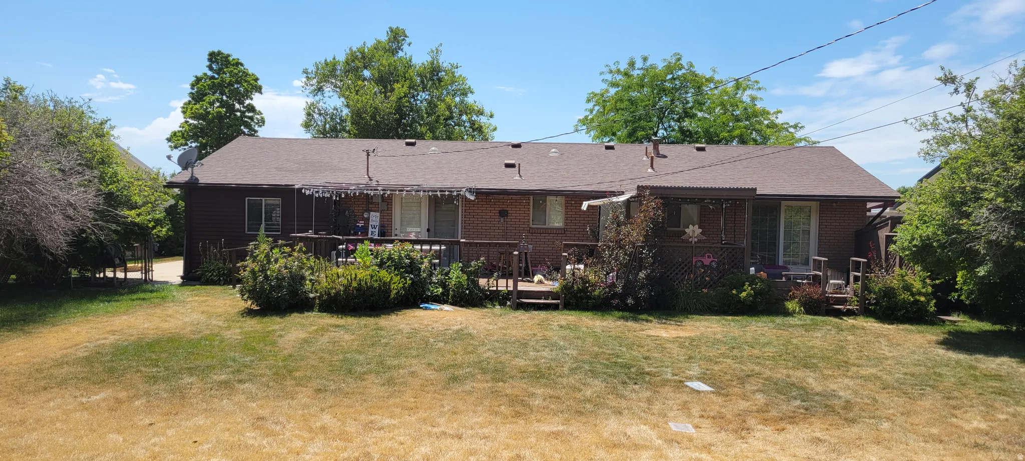 Rear exterior featuring a full-width wood deck