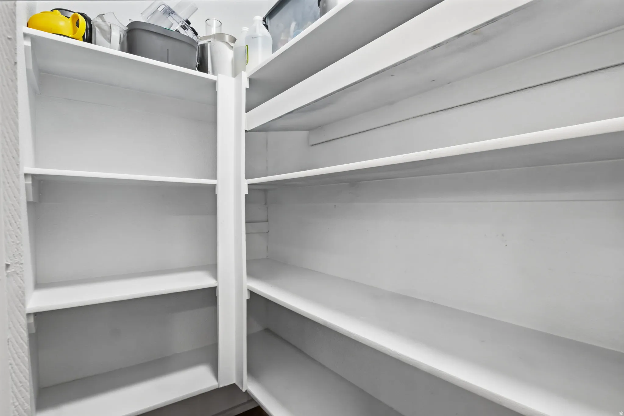 Spacious pantry featuring multiple tiers of white shelving
