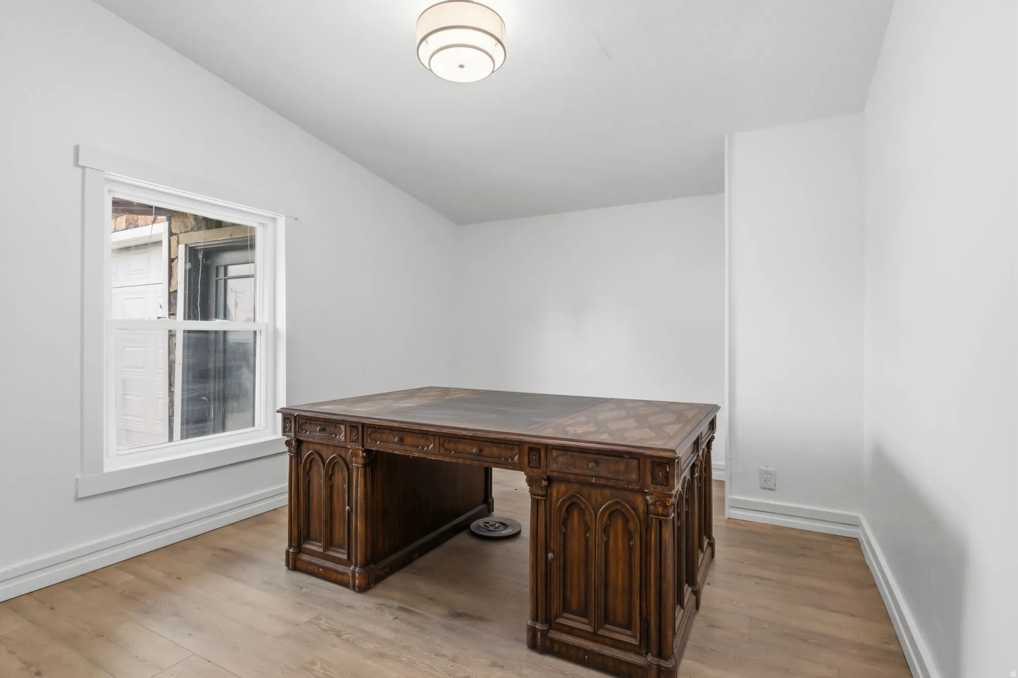 Bright room featuring wood-finish flooring, white walls, and a contemporary ceiling fixture