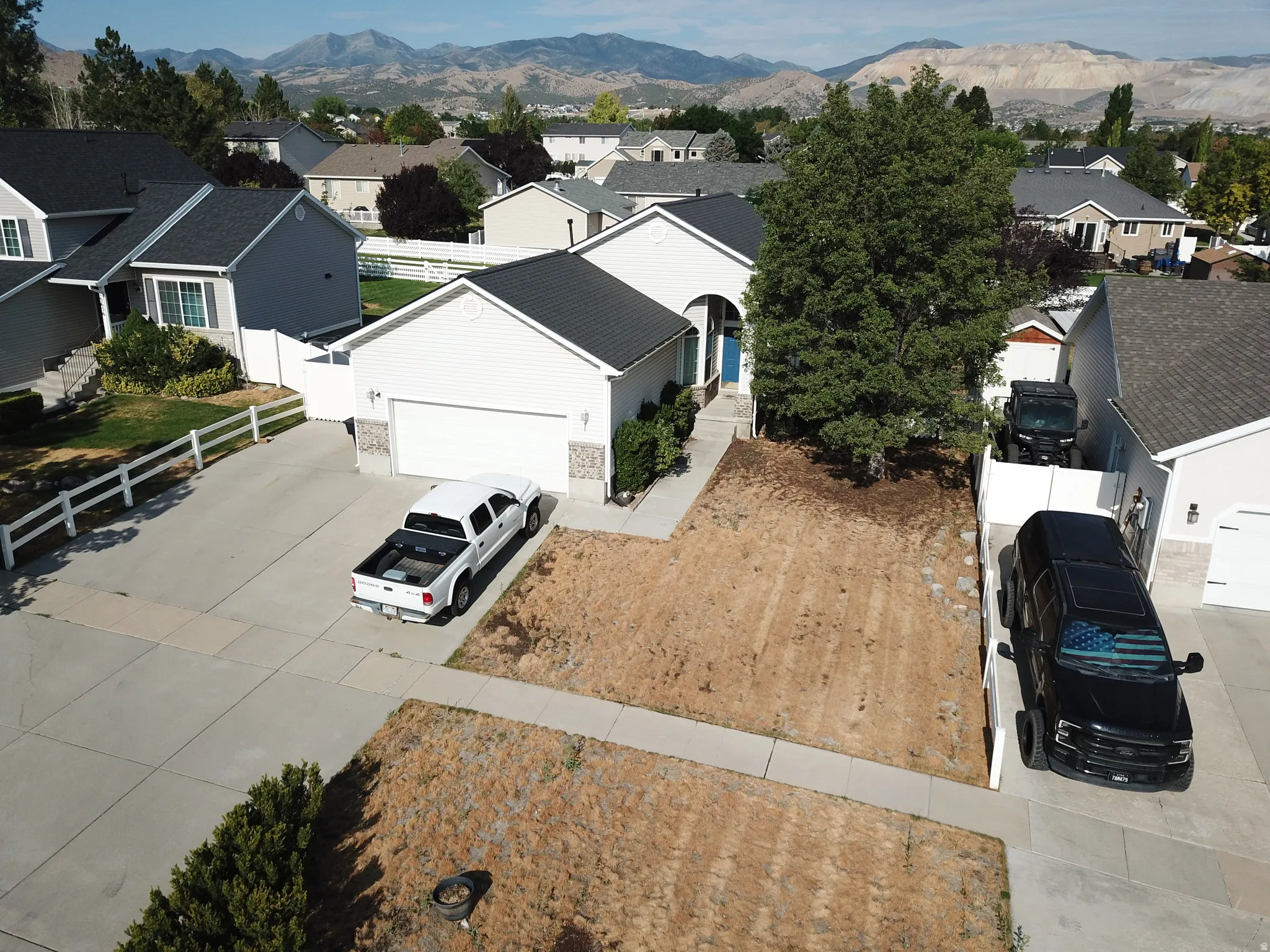 Ranch-style residence featuring a two-car garage, concrete driveway, and a partially landscaped front yard